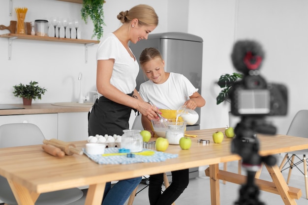 Foto gratuita tiro completo niña y mujer cocinando