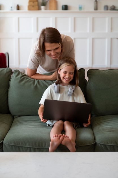 Tiro completo niña y mujer con laptop