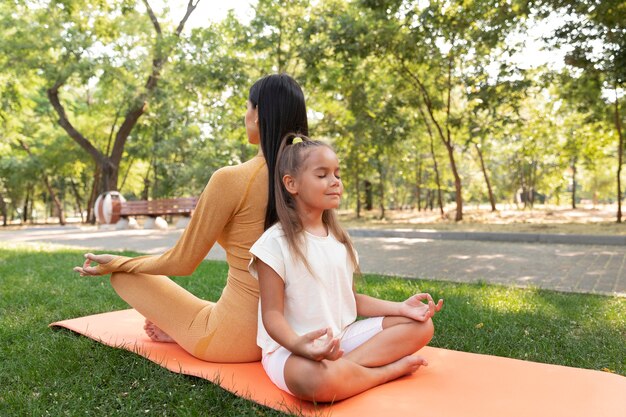 Foto gratuita tiro completo niña y mujer meditando