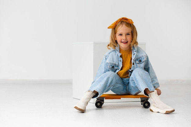 Tiro completo niña sentada en patineta