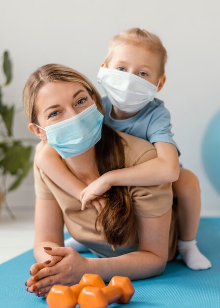 Foto gratuita tiro completo niño y mujer con máscaras