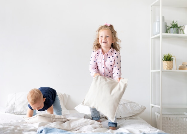 Tiro completo niños jugando con almohadas