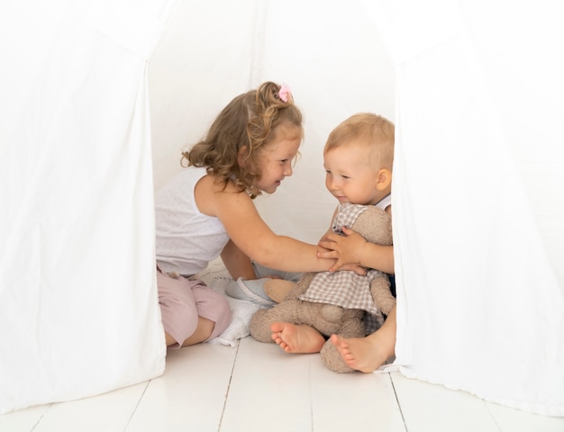 Foto gratuita tiro completo niños jugando en la carpa