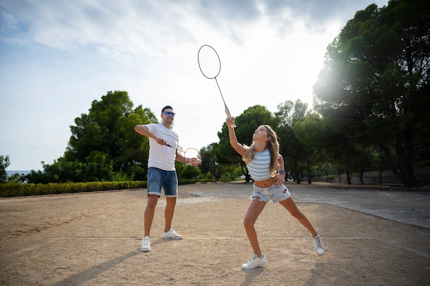 Foto gratuita tiro completo padre y niña jugando al bádminton