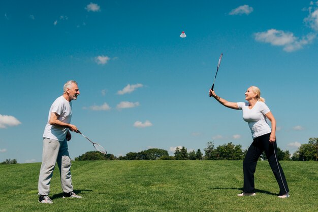 Tiro completo pareja jugando tenis al aire libre