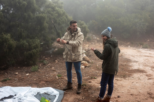 Tiro completo personas levantando una carpa