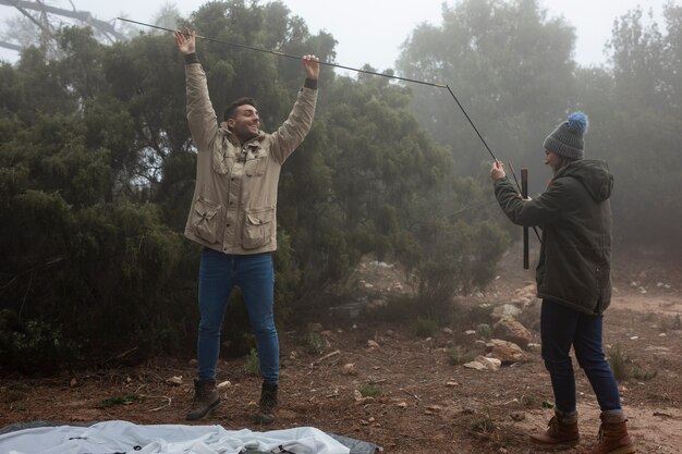 Tiro completo personas levantando una carpa