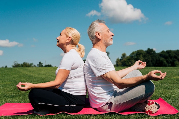 Foto gratuita tiro completo personas mayores meditando juntos