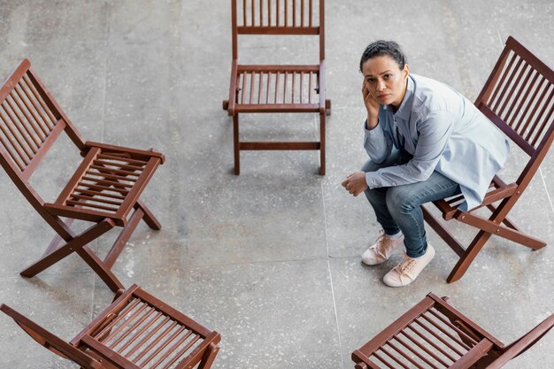 Tiro completo triste mujer sentada en una silla