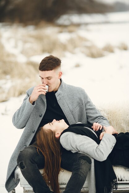 Tiro de estilo de vida de pareja en bosque nevado. Personas que pasan las vacaciones de invierno al aire libre.