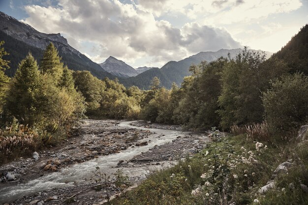 Tiro horizontal del arroyo de St. Maria Val Müstair, Engadin, Suiza bajo el cielo nublado