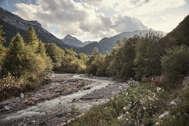 Tiro horizontal del arroyo de St. Maria Val Müstair, Engadin, Suiza bajo el cielo nublado