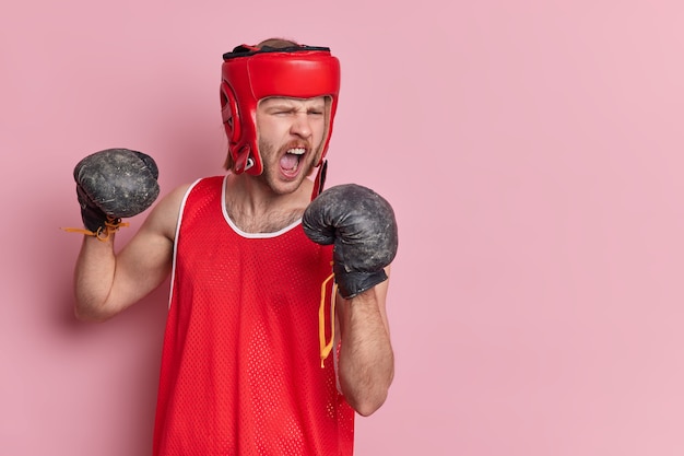 Foto gratuita tiro horizontal de boxeador masculino sin afeitar emocional grita en voz alta mantiene la boca abierta