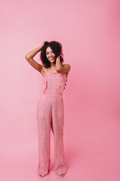 Foto gratuita tiro integral de sonriente joven africana. modelo endereza su cabello rizado.