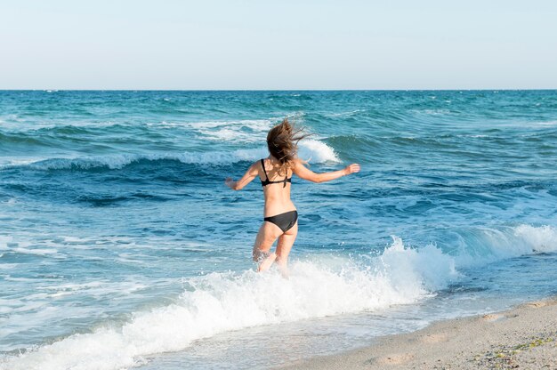 Tiro largo de hermosa chica en la playa