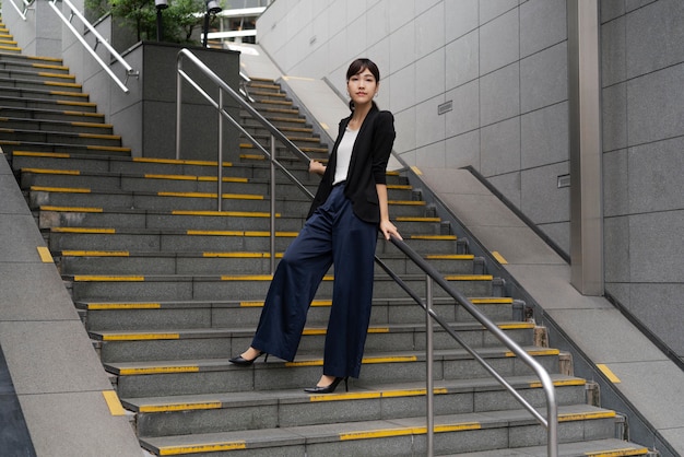 Foto gratuita tiro largo de hermosa mujer de negocios en escaleras