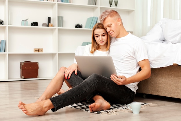 Foto gratuita tiro largo hombre y mujer mirando una película en la computadora portátil