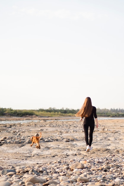 Tiro largo mujer caminando con su perro