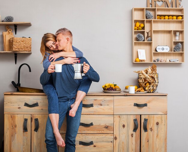 Tiro largo pareja abrazándose en la cocina