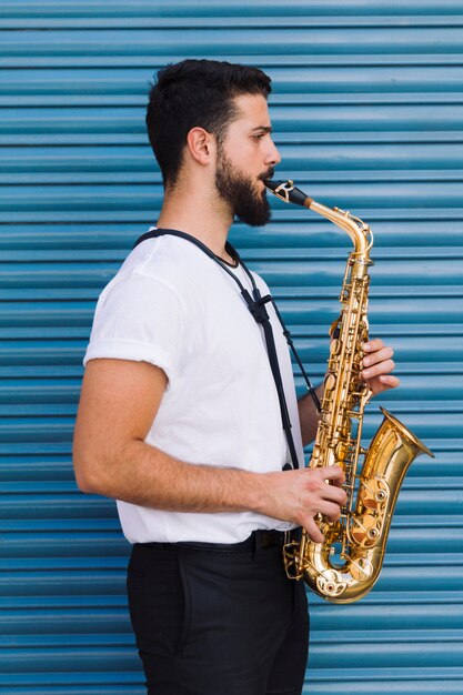 Tiro lateral lateral hombre tocando el saxofón