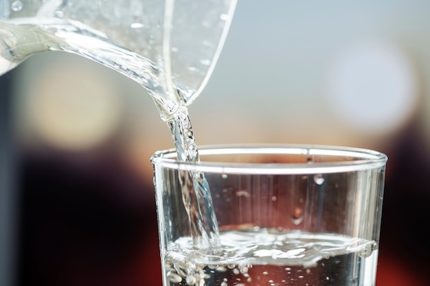 Foto gratuita tiro de macro de verter agua en un vaso