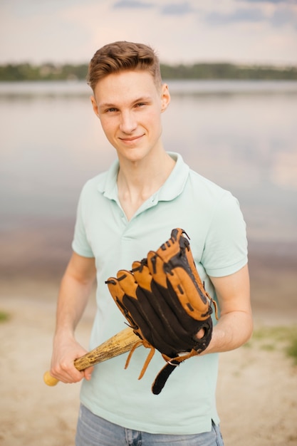 Foto gratuita tiro medio adolescente sonriente con equipo de béisbol