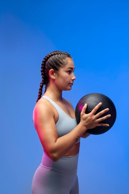 Tiro medio ajuste mujer sosteniendo la bola