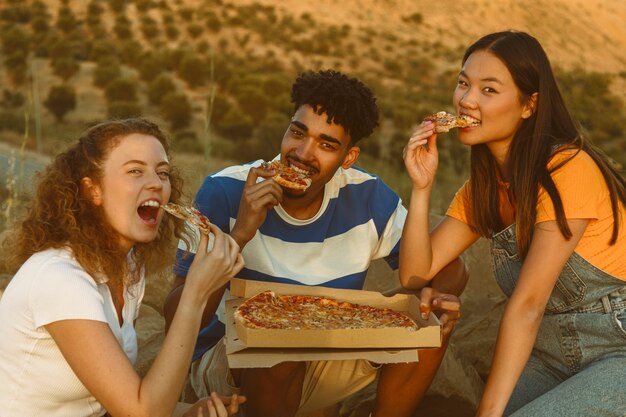 Tiro medio amigos comiendo pizza