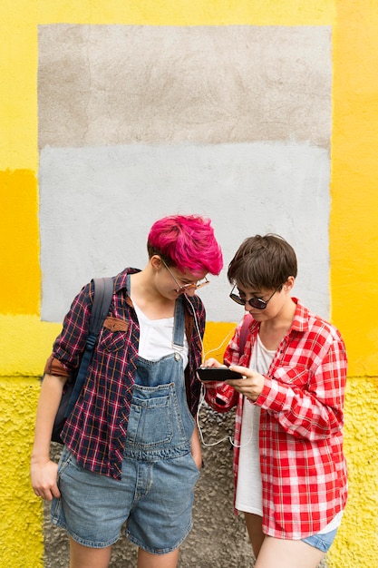 Tiro medio amigos mirando el teléfono