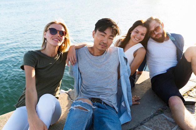 Foto gratuita tiro medio amigos posando junto al mar