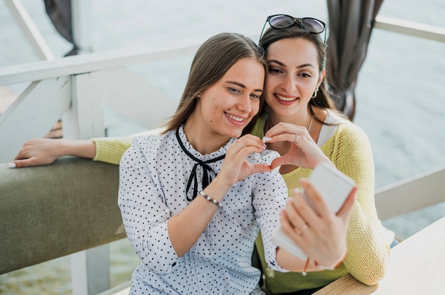 Tiro medio amigos sonrientes tomando una selfie