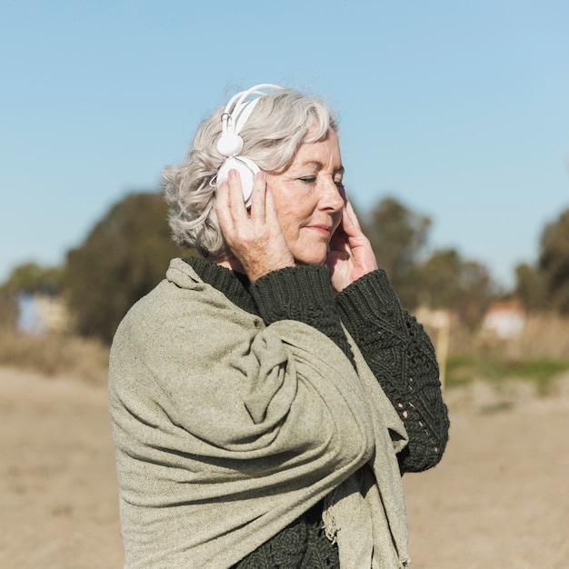 Tiro medio anciana con auriculares