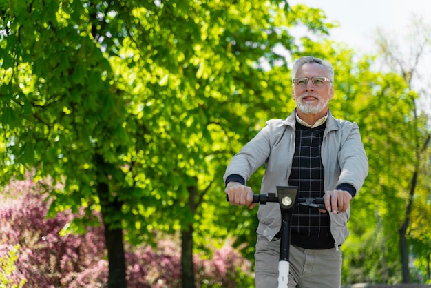 Tiro medio anciano con scooter al aire libre