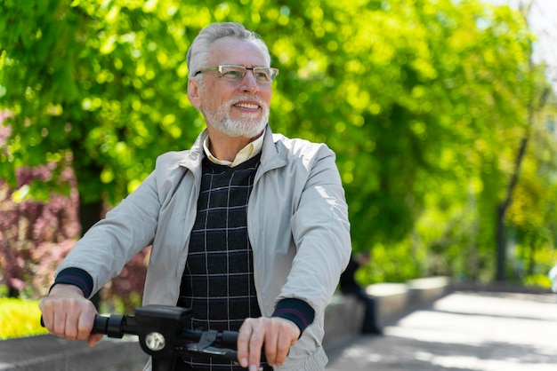 Tiro medio anciano con scooter fuera