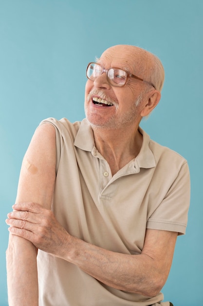 Tiro medio anciano sonriente después de la vacuna