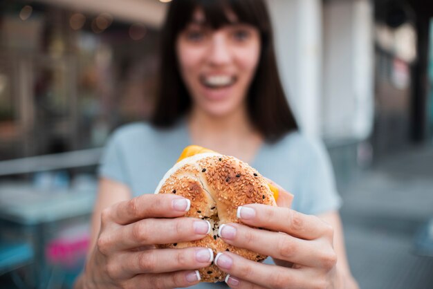 Tiro medio chica borrosa con hamburguesa