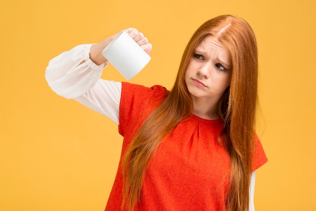 Foto gratuita tiro medio chica molesta sosteniendo la taza