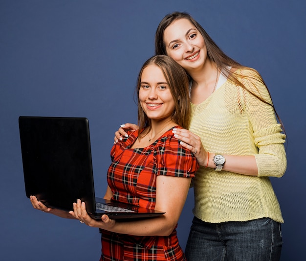 Foto gratuita tiro medio chicas sonrientes posando con laptop