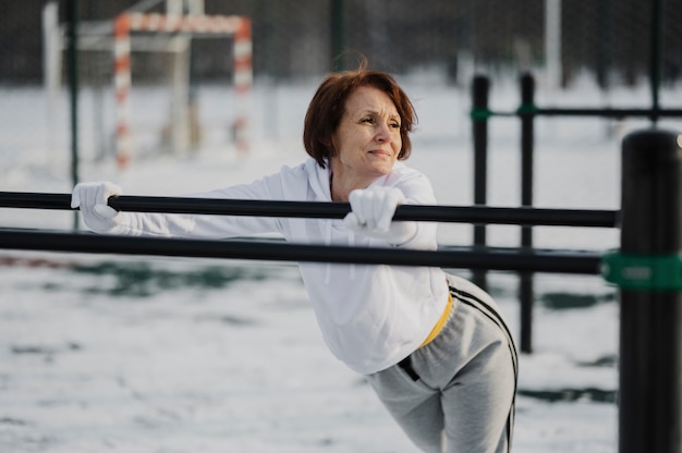 Tiro medio colocar mujer senior al aire libre