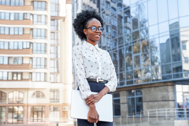 Tiro medio elegante mujer africana en ropa de oficina