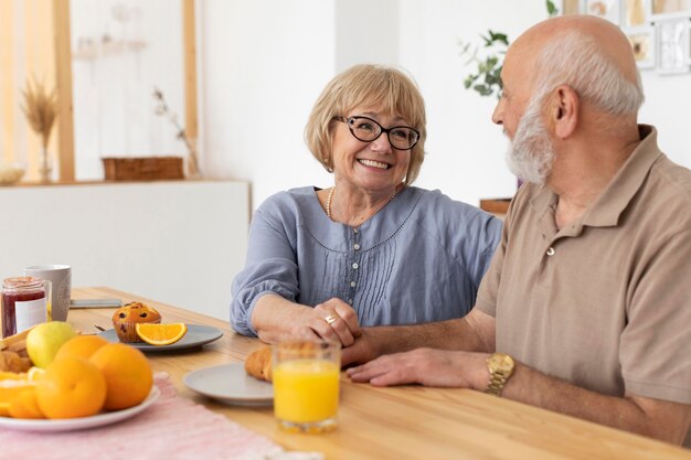 Tiro medio feliz pareja senior en la mesa