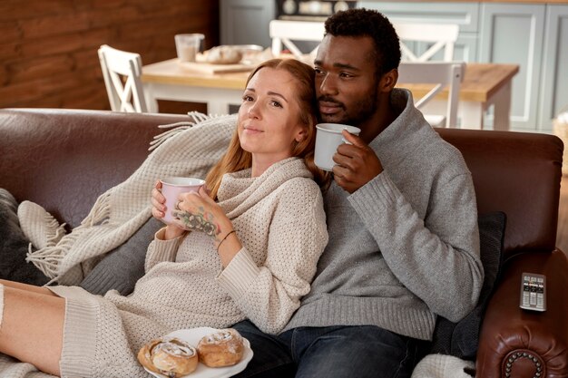 Tiro medio feliz pareja sentados juntos