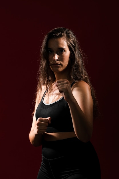 Tiro medio en forma mujer con cabello largo mirando a la cámara