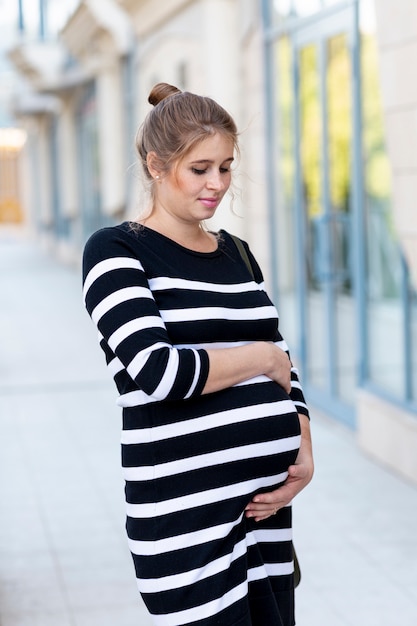 Tiro medio futura madre con los brazos sobre su vientre