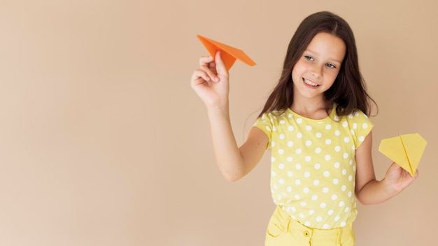 Foto gratuita tiro medio hermosa chica posando con aviones de papel