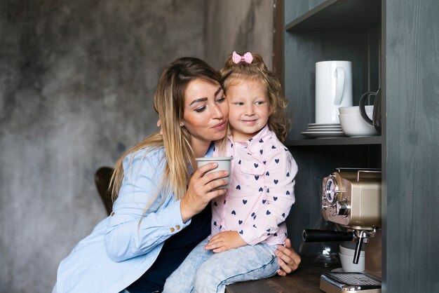 Tiro medio hija con madre en la cocina