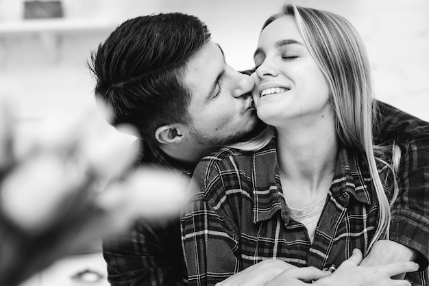 Foto gratuita tiro medio hombre besando a mujer en la mejilla en escala de grises