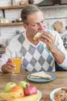 Foto gratuita tiro medio hombre comiendo un sandwich