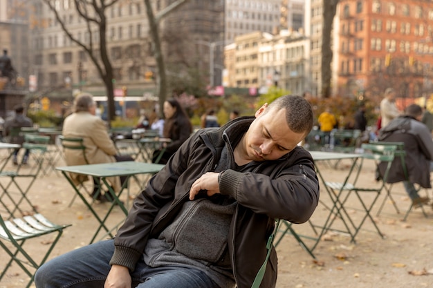 Tiro medio hombre durmiendo en una silla fuera