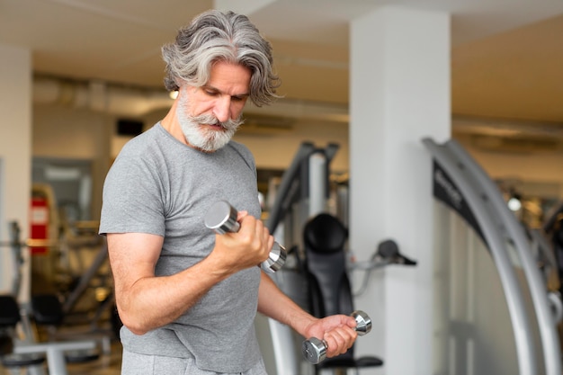 Tiro medio hombre entrenando con pesas